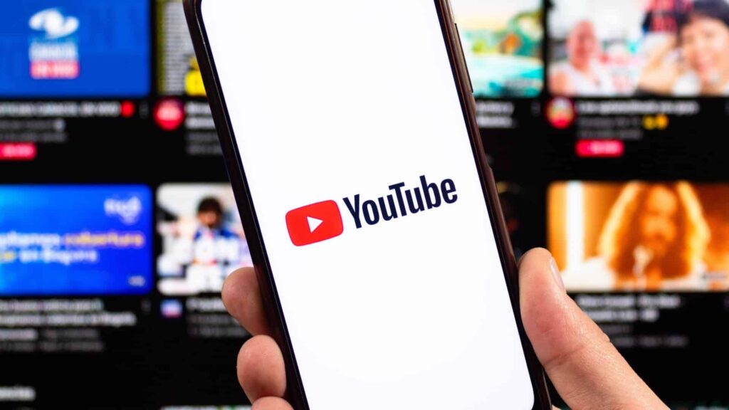 YouTube logo on smartphone with blurred interface at background