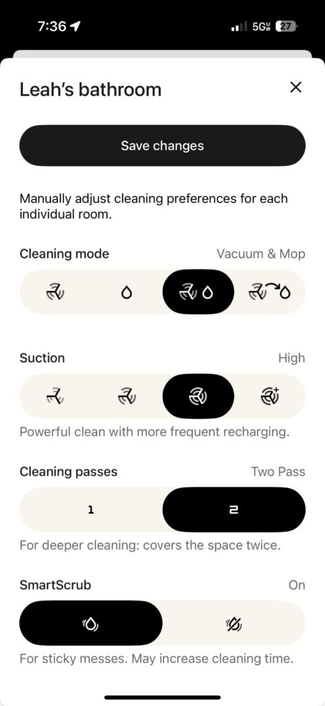 Roborock Saros 10 robot vacuum cleaning bathroom floor near pile of laundry