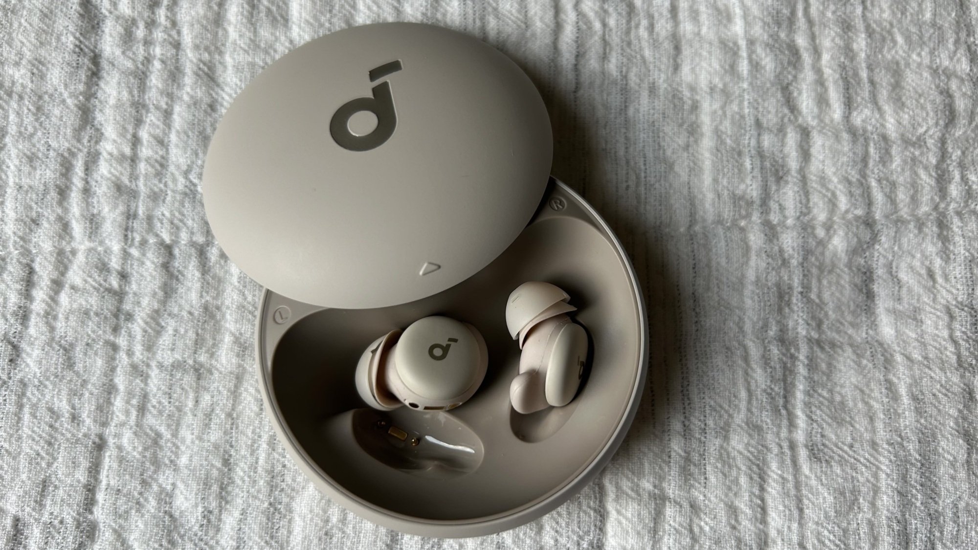 gray pair of soundcore sleep earbuds in their case