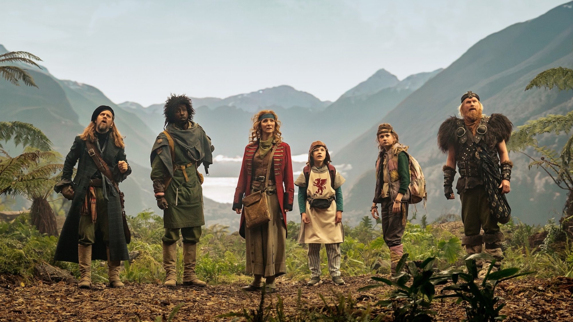 The Time Bandits cast stand on a forest-covered island.