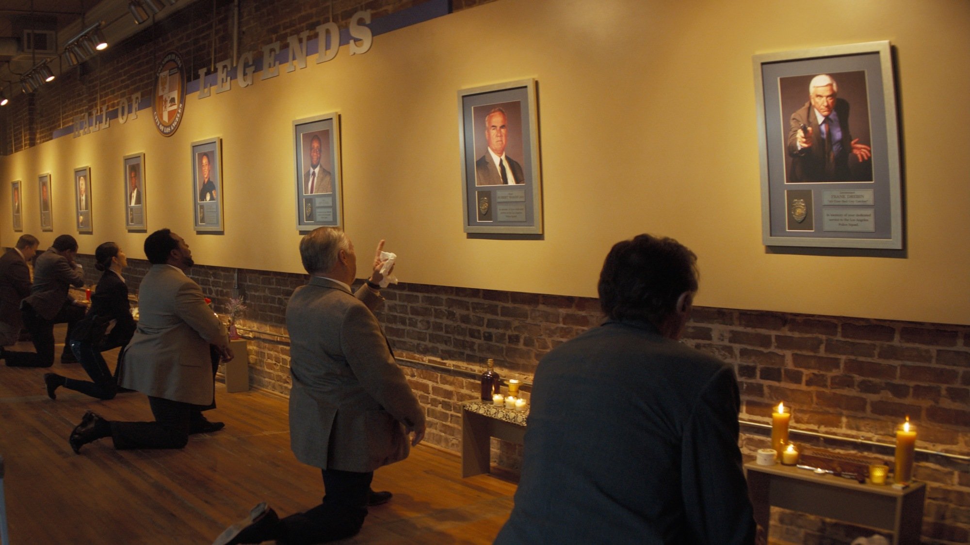 'The Naked Gun' cops of 2025 kneel before images of the original stars.