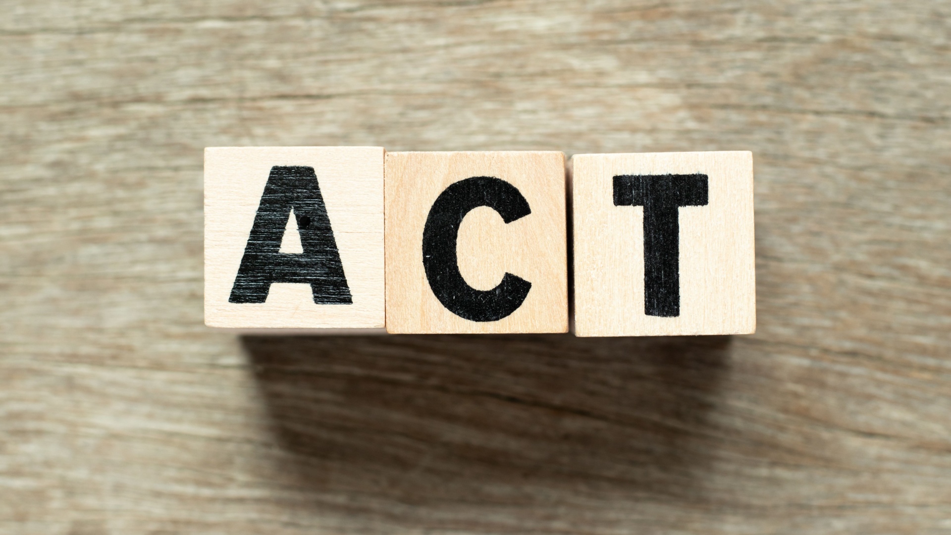 ACT letter blocks on wooden background