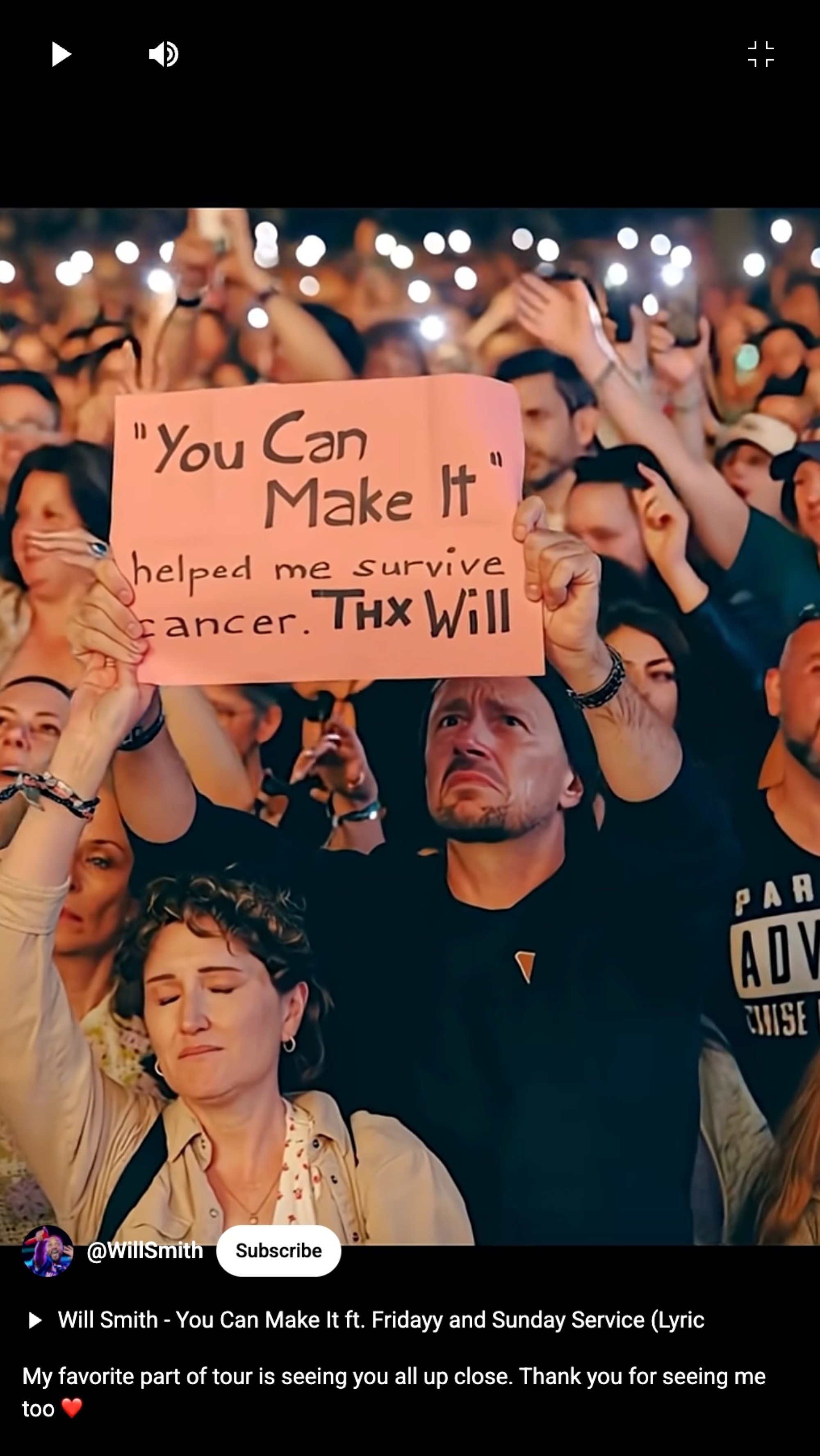 seemingly ai-generated video still of a man holding up a sign at a will smith concert